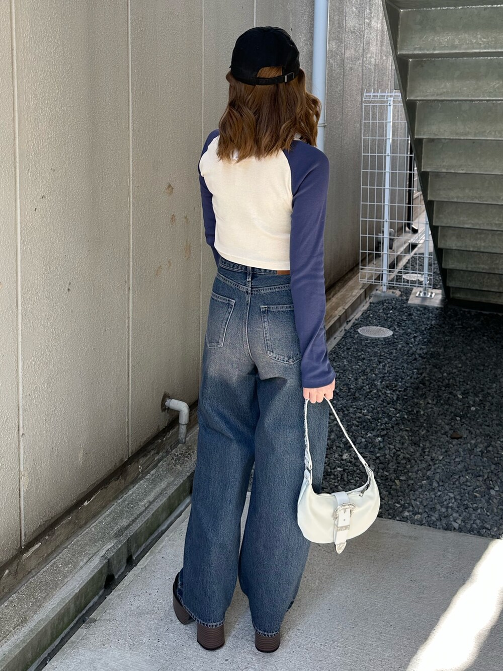 ブルー系のTシャツ/カットソー、ホワイト系のショルダーバッグ、ブルー系のデニムパンツを着用したレディースの春コーディネートの4枚目の写真