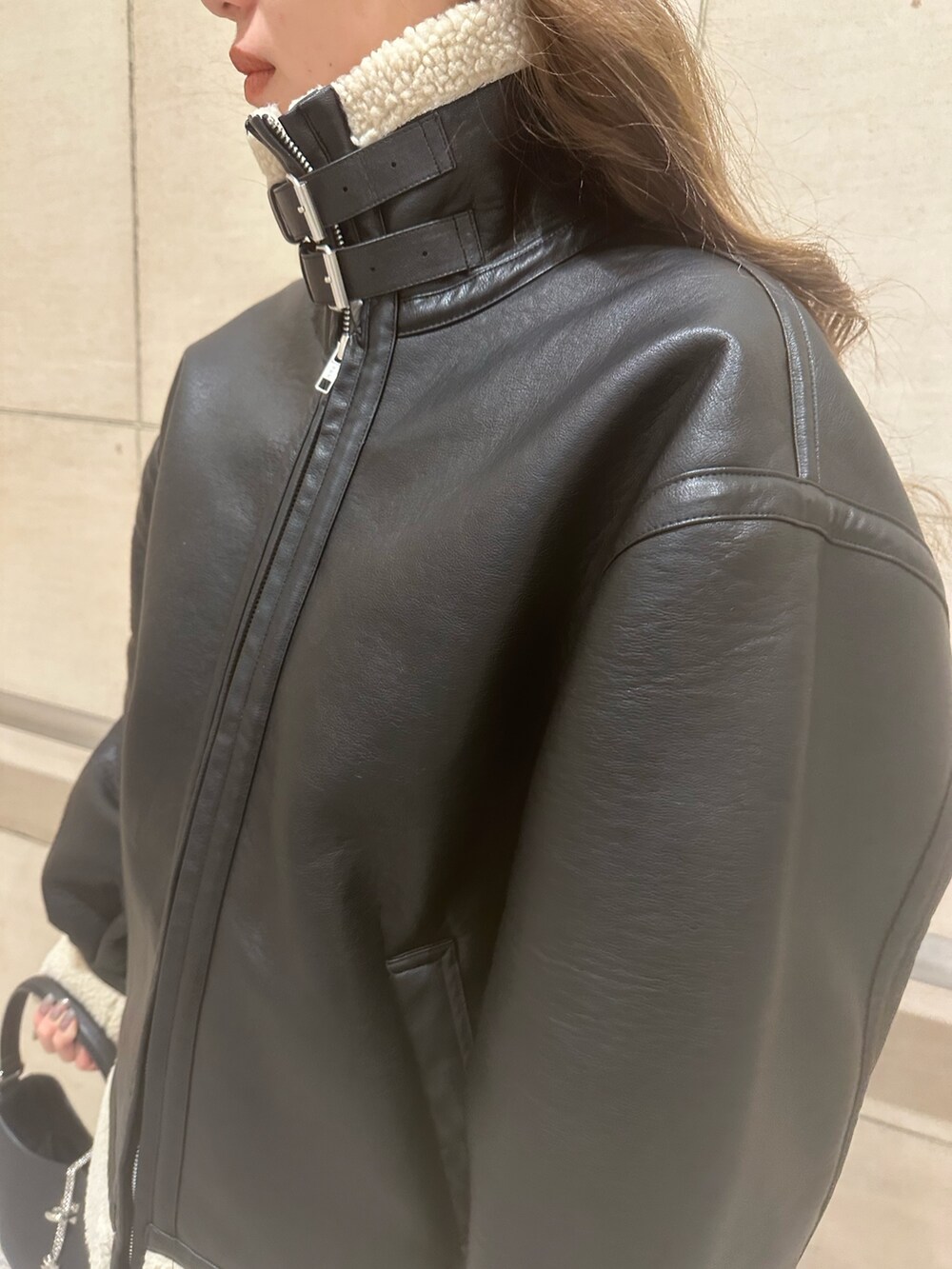 グレー系のスウェット、ブラック系のブルゾン、ブラック系のハンドバッグを着用したレディースの冬コーディネートの6枚目の写真