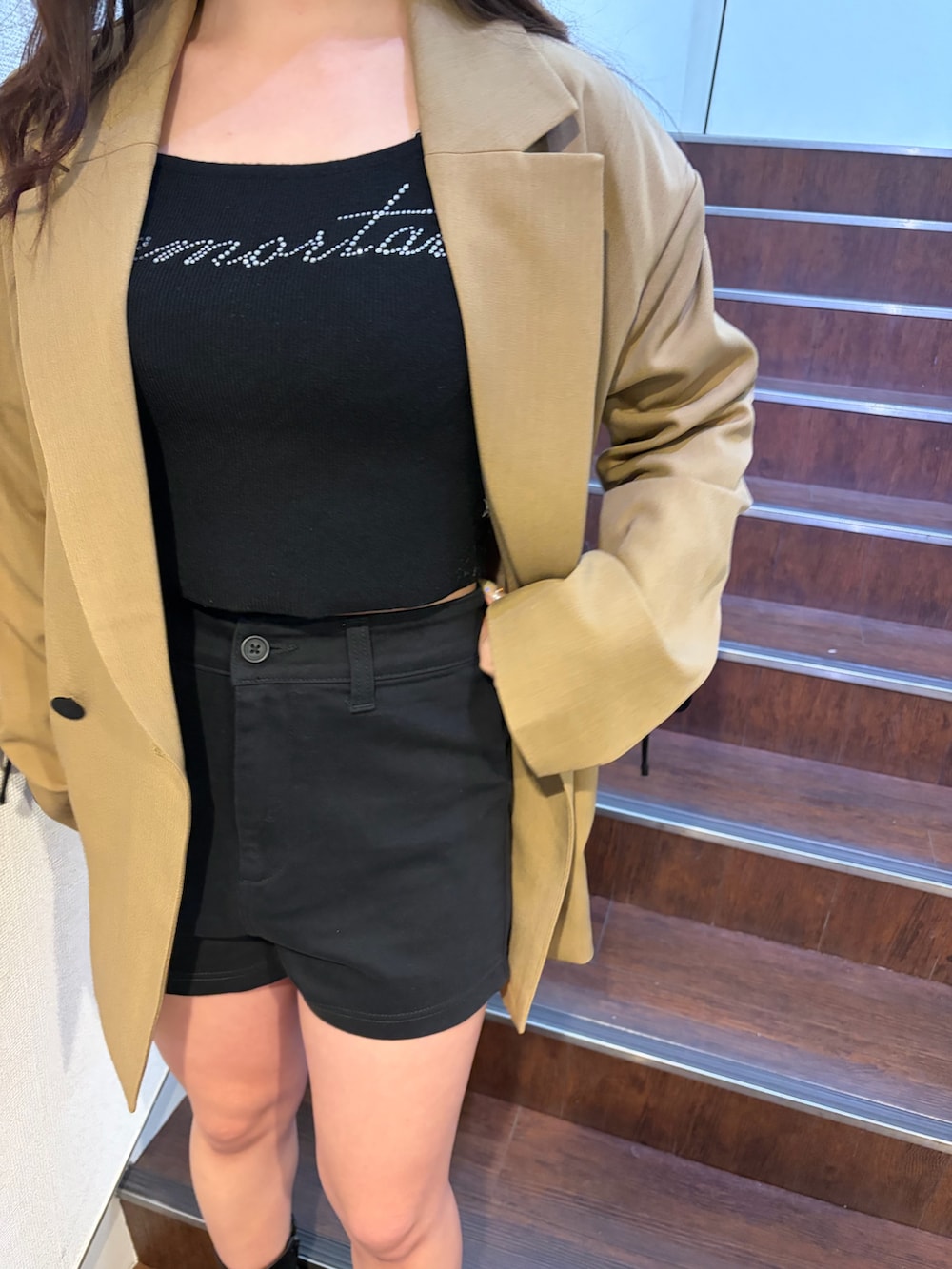 ブラウン系のテーラードジャケット、ブラック系のニット/セーター、ブラック系のその他パンツを着用したレディースの春コーディネートの6枚目の写真