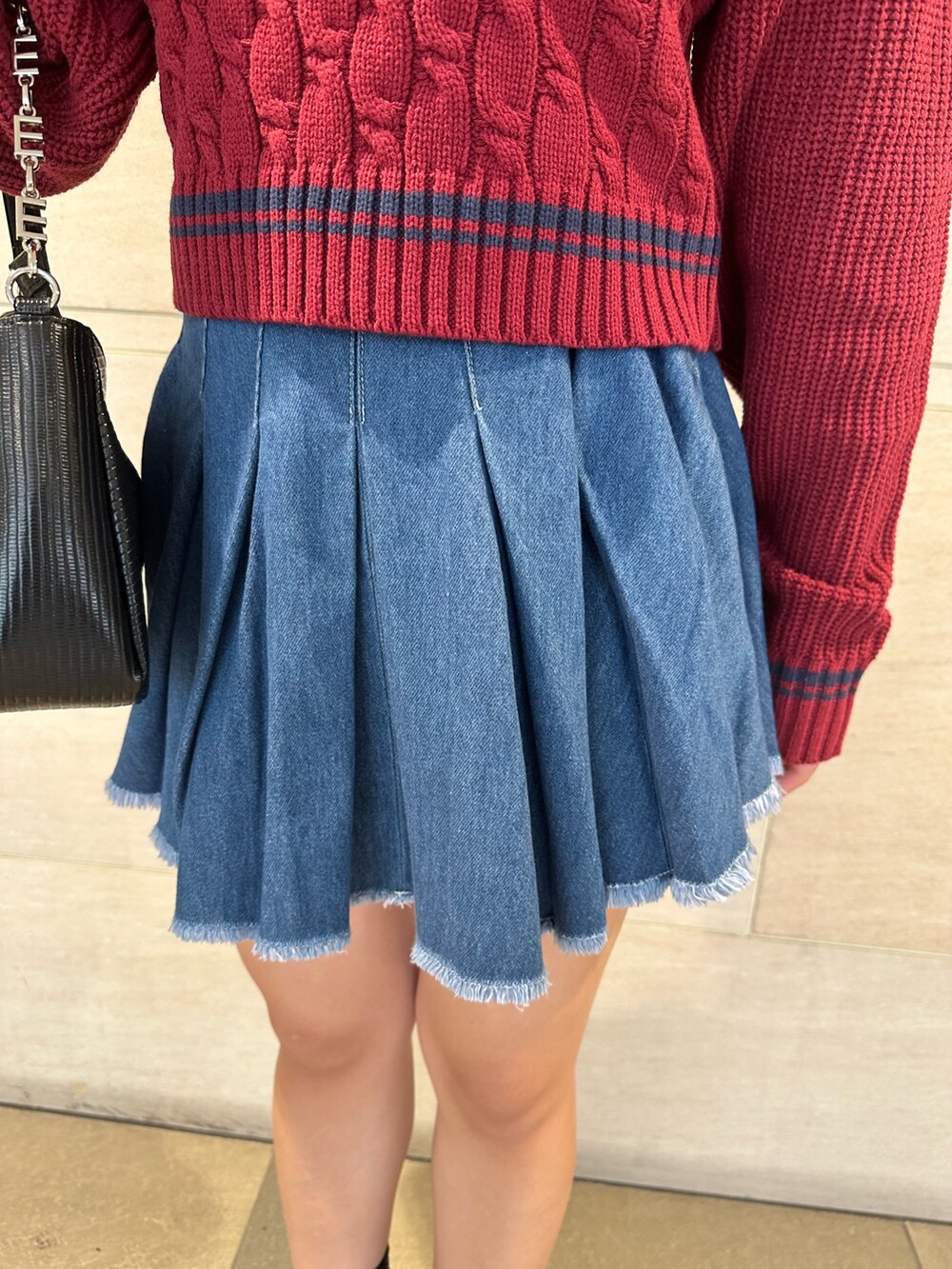 ブルー系のデニムスカート、レッド系のニット/セーター、その他のブーツを着用したレディースの夏コーディネートの7枚目の写真