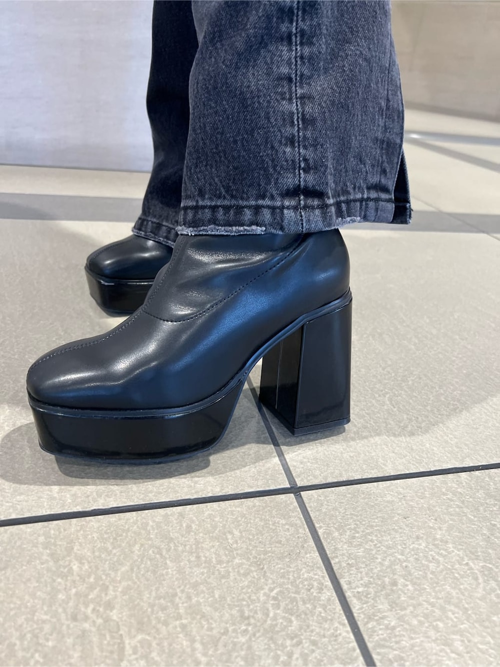 グリーン系のカーディガン/ボレロ、ホワイト系のチューブトップ、ブラック系のデニムパンツを着用したレディースの秋コーディネートの6枚目の写真