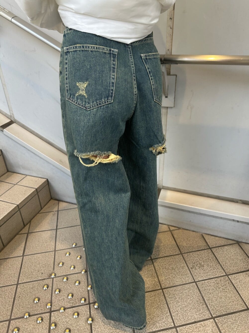 ブルー系のデニムパンツ、ホワイト系のブルゾン、グレー系のTシャツ/カットソーを着用したレディースの冬コーディネートの7枚目の写真