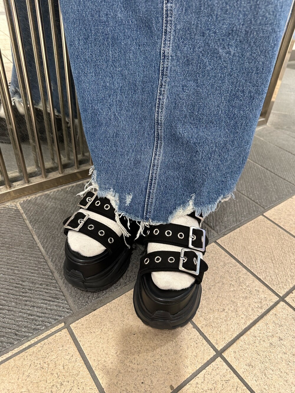 ブルー系のデニムスカート、ブラック系のタンクトップ、ブラック系のサンダルを着用したレディースの春コーディネートの9枚目の写真