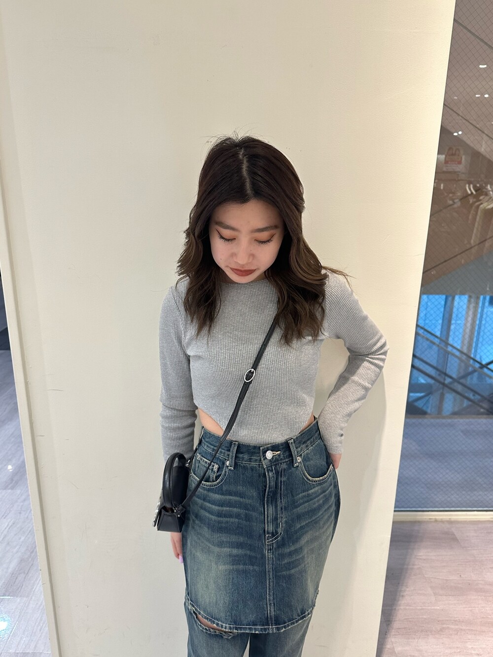 ブルー系のデニムパンツ、グレー系のTシャツ/カットソー、ブラック系のブーツを着用したレディースの冬コーディネートの4枚目の写真