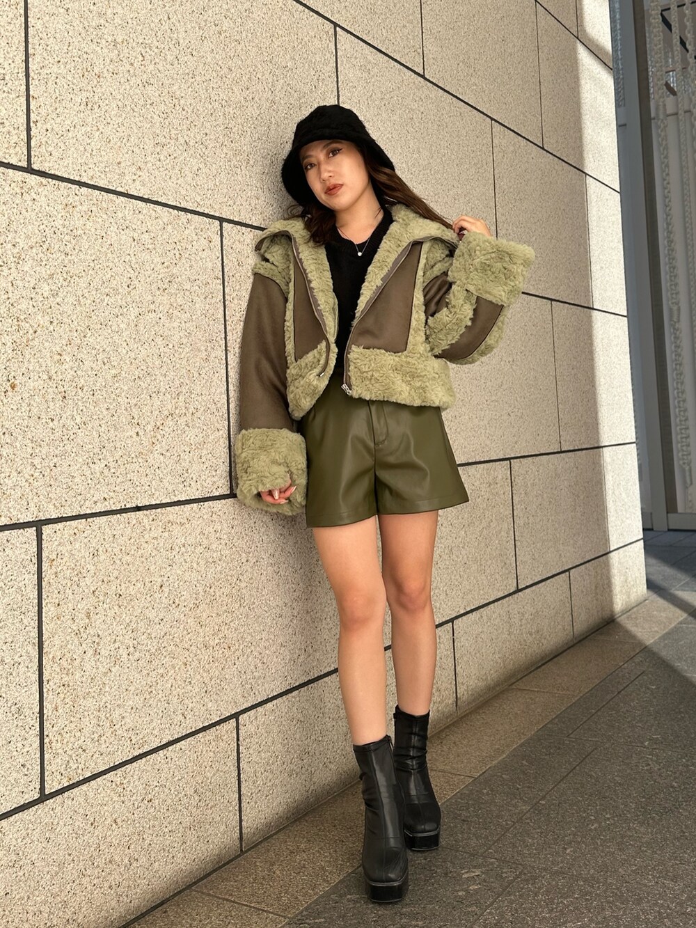 グリーン系のその他パンツ、ブラウン系のムートンコート、ブラック系のブーツを着用したレディースの秋コーディネートの2枚目の写真