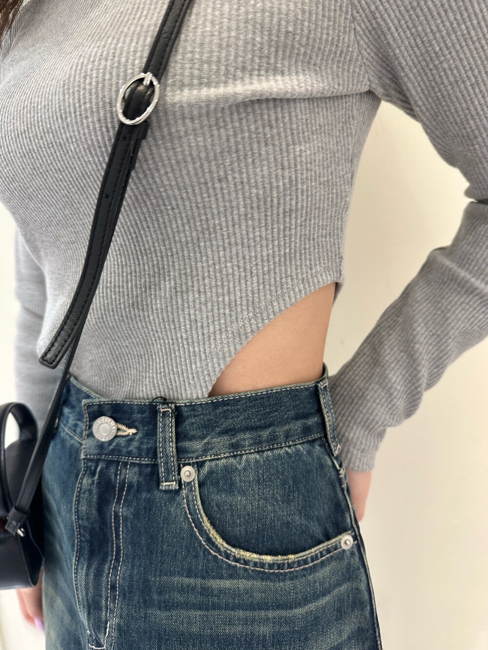 ブルー系のデニムパンツ、グレー系のTシャツ/カットソー、ブラック系のブーツを着用したレディースの冬コーディネートの5枚目の写真