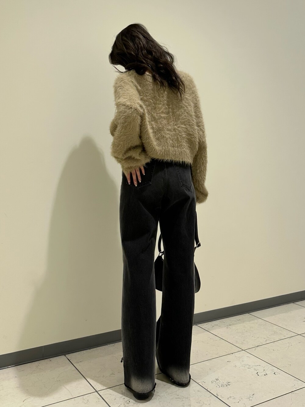 ベージュ系のニット/セーター、ブラック系のショルダーバッグ、ブラック系のブーツを着用したレディースの冬コーディネートの3枚目の写真