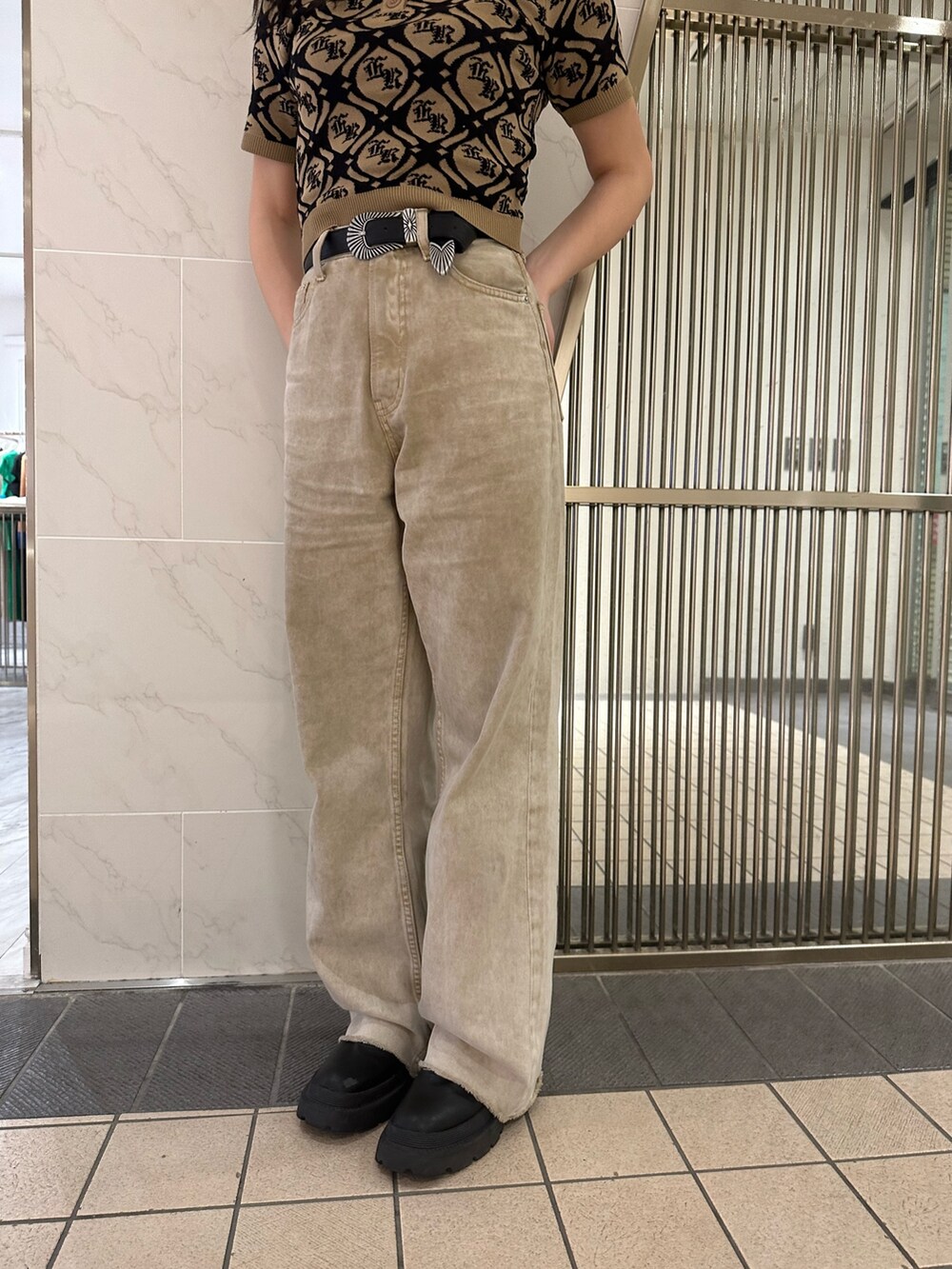 ベージュ系のニット/セーター、ベージュ系のデニムパンツ、ブラック系のブーツを着用したレディースの春コーディネートの7枚目の写真