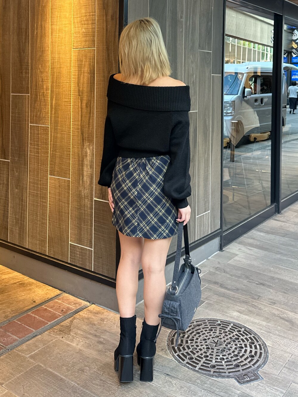 ブラック系のニット/セーター、その他のブーツ、ブラック系のハンドバッグを着用したレディースの秋コーディネートの4枚目の写真