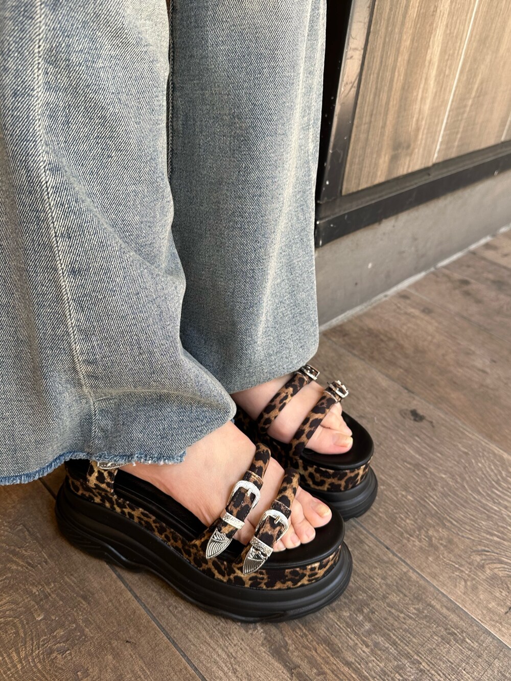 ブラック系のニット/セーター、ブルー系のデニムパンツ、その他のサンダルを着用したレディースの春コーディネートの8枚目の写真