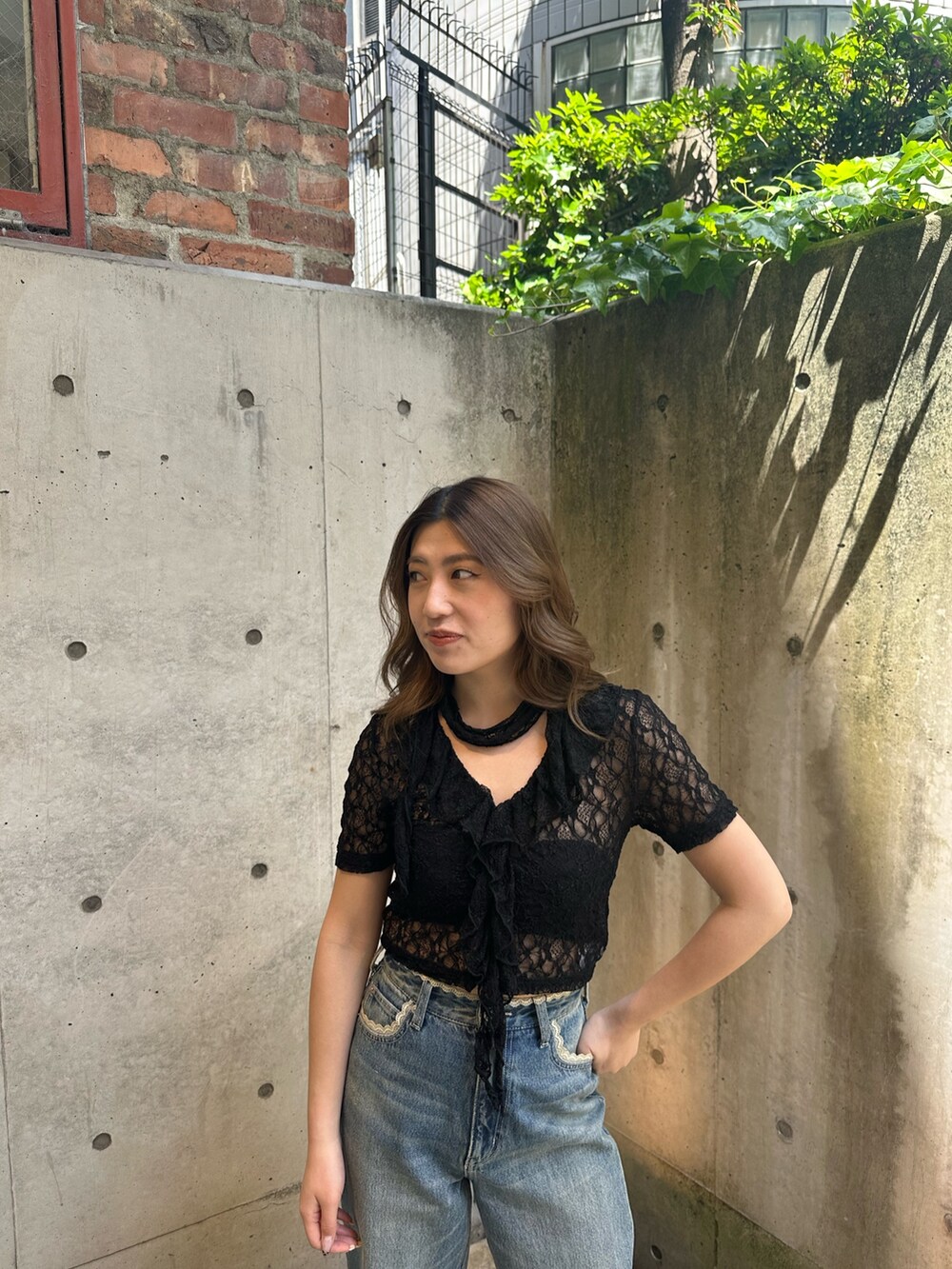 ブルー系のデニムパンツ、ブラウン系のブーツ、ブラック系のTシャツ/カットソーを着用したレディースの春コーディネートの5枚目の写真