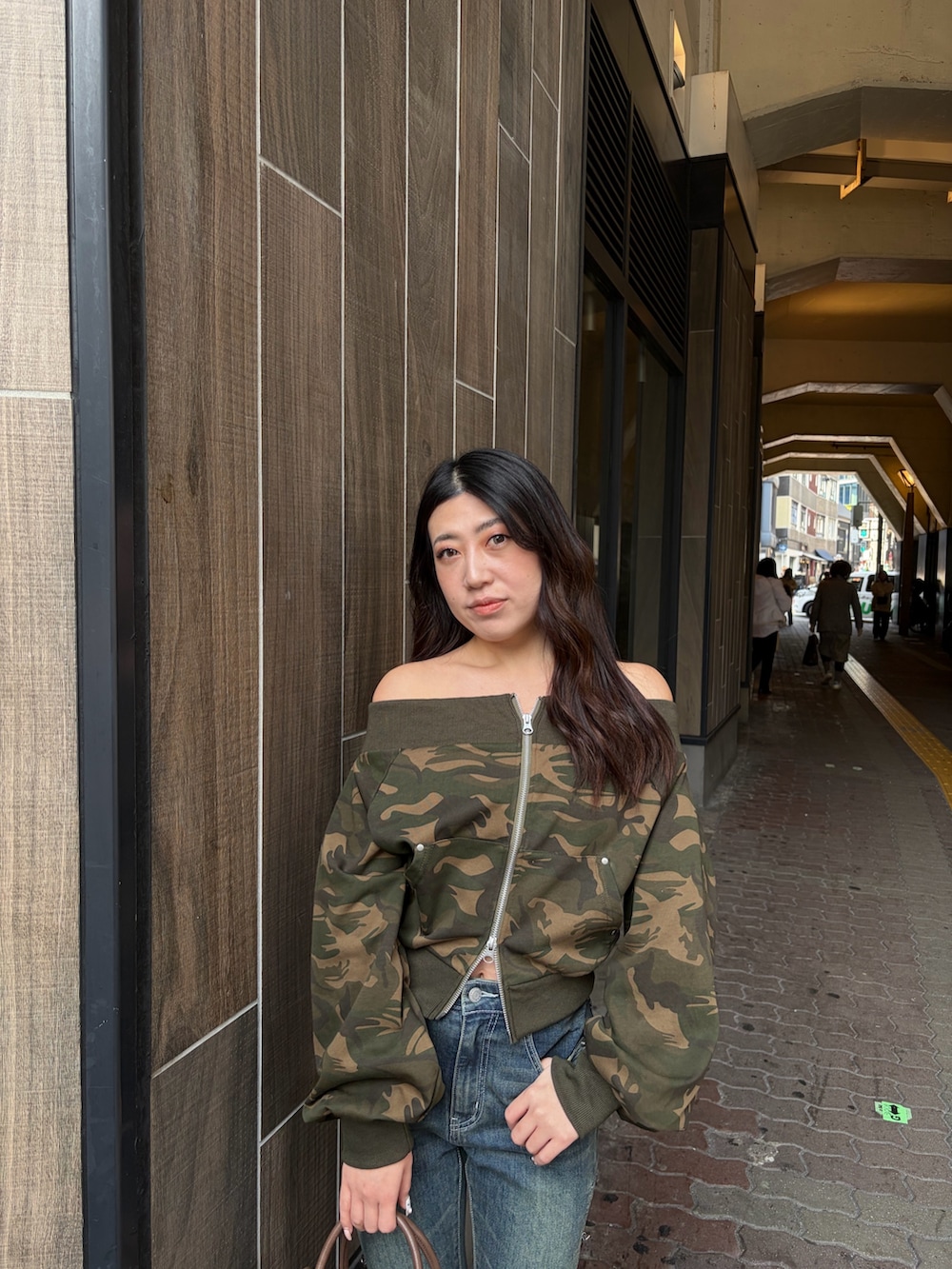 ブルー系のデニムパンツ、ブラウン系のボストンバッグ、ブラック系のブーツを着用したレディースの冬コーディネートの4枚目の写真