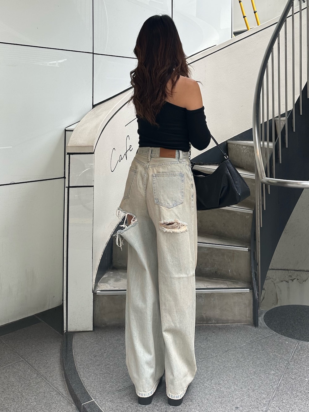 ブルー系のデニムパンツ、ブラック系のサンダル、ブラック系のTシャツ/カットソーを着用したレディースの秋コーディネートの3枚目の写真