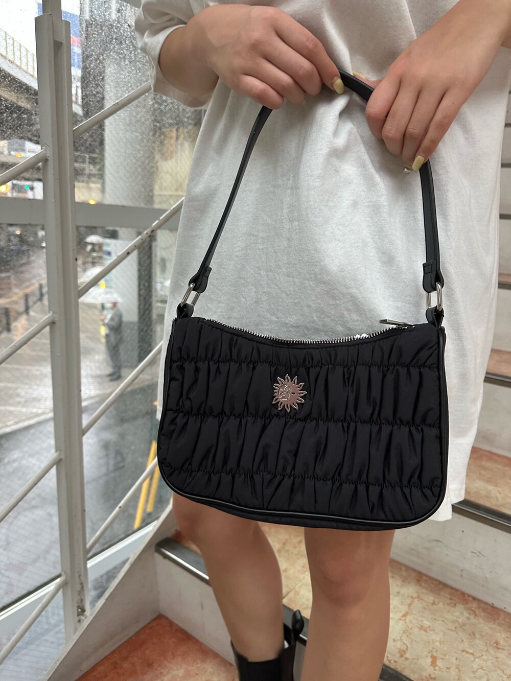 ホワイト系のTシャツ/カットソー、ブラック系のブーツ、ブラック系のハンドバッグを着用したレディースの夏コーディネートの7枚目の写真