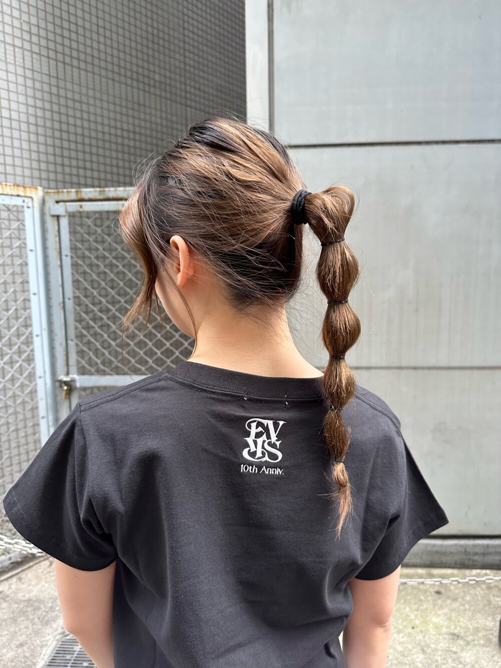 ブラック系のTシャツ/カットソー、ブラック系のスニーカー、ブルー系のデニムパンツを着用したレディースの春コーディネートの8枚目の写真