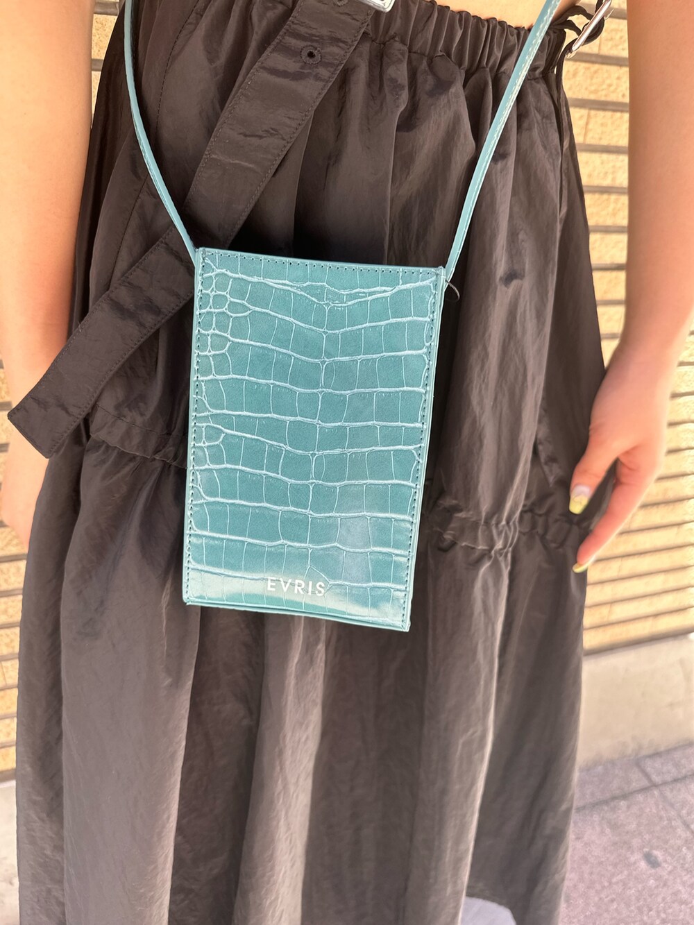 ブラック系のサンダル、ブルー系のショルダーバッグ、ブラック系のワンピースを着用したレディースの夏コーディネートの7枚目の写真