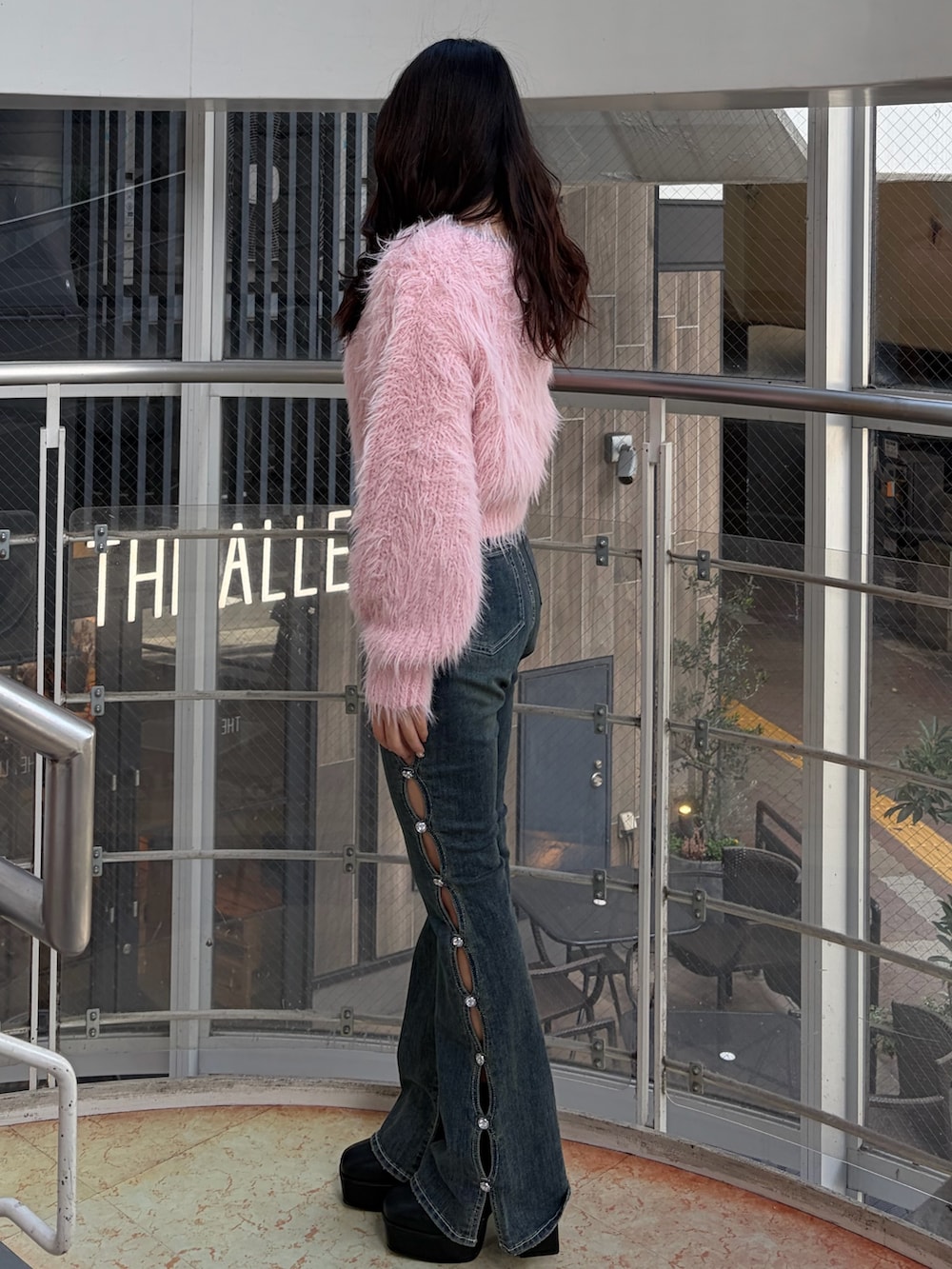 ブルー系のデニムパンツ、ピンク系のニット/セーター、ブラック系のブーツを着用したレディースの冬コーディネートの4枚目の写真