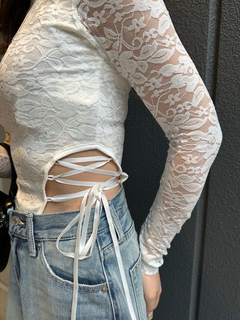 ブルー系のデニムパンツ、ホワイト系のTシャツ/カットソー、ブラック系のショルダーバッグを着用したレディースの春コーディネートの5枚目の写真