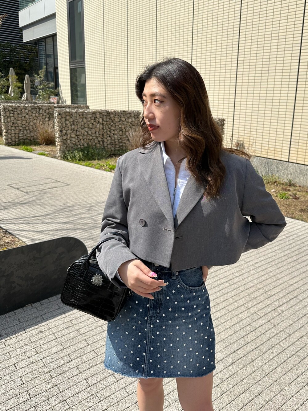 ブラック系のブーツ、グレー系のテーラードジャケット、ホワイト系のシャツ/ブラウスを着用したレディースの春コーディネートの3枚目の写真