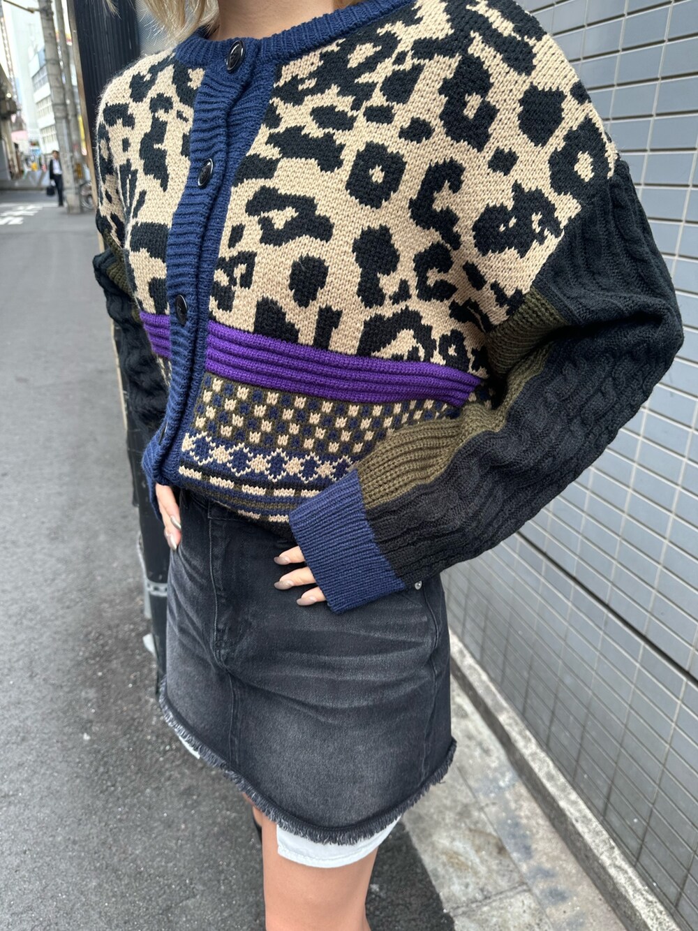 ブラック系のブーツ、ベージュ系のニット/セーター、ブラック系のデニムスカートを着用したレディースの冬コーディネートの5枚目の写真