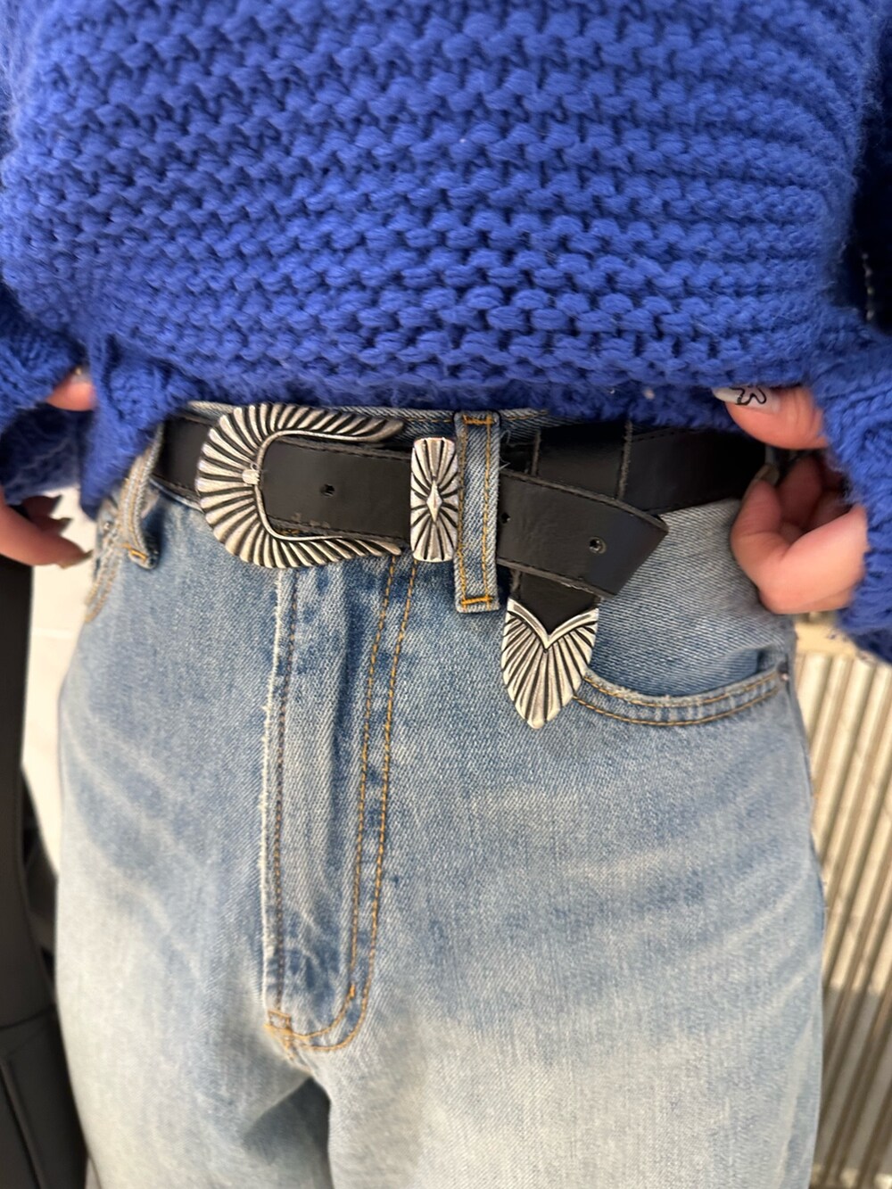 ブラック系のハンドバッグ、ブルー系のニット/セーター、ブルー系のデニムパンツを着用したレディースの冬コーディネートの5枚目の写真