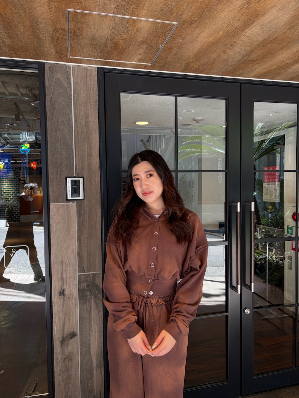 ブラウン系のスウェットパンツ、ブラウン系のパーカー、ブラック系のブーツを着用したレディースの春コーディネートの4枚目の写真