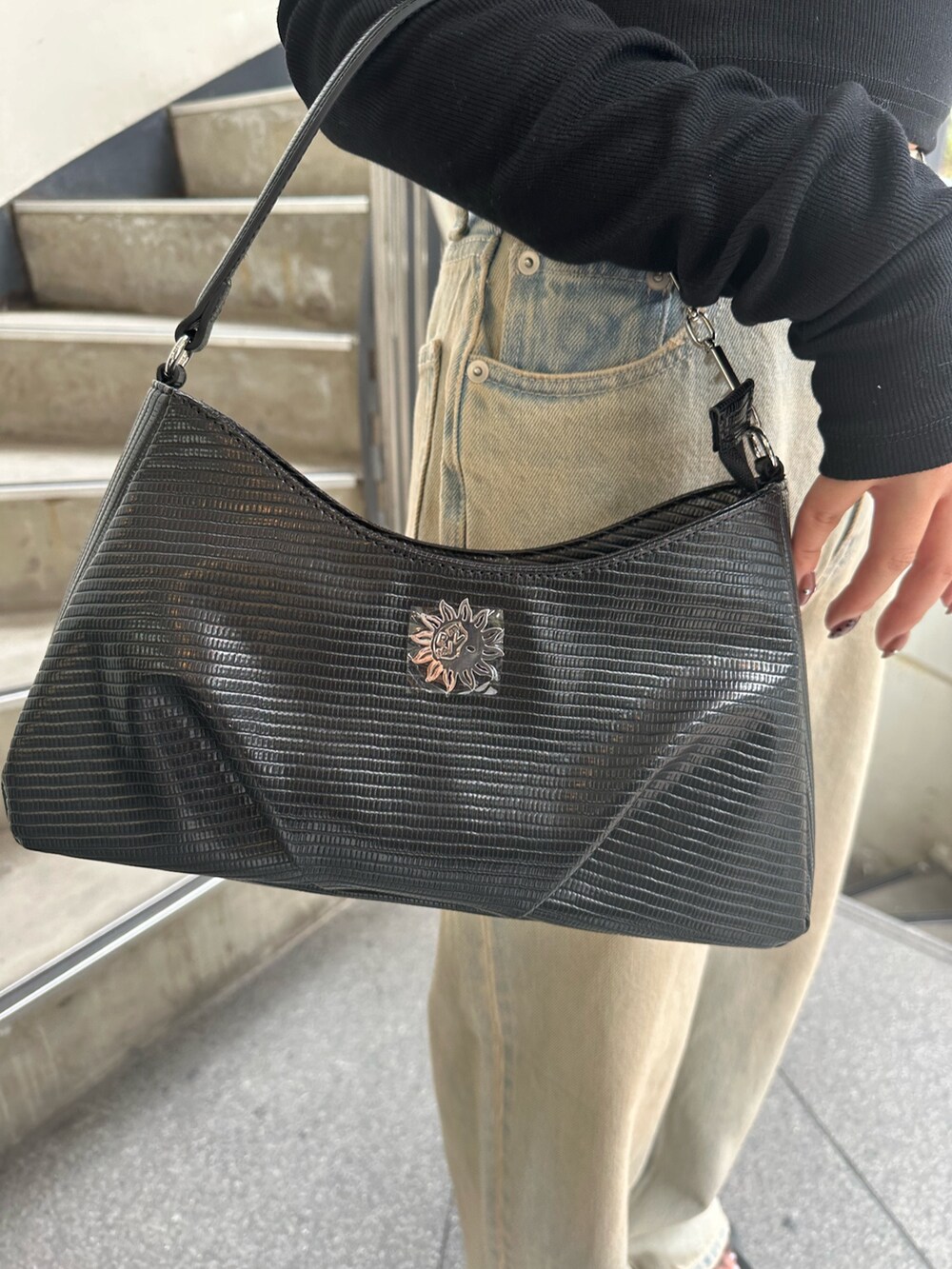 ブルー系のデニムパンツ、ブラック系のサンダル、ブラック系のTシャツ/カットソーを着用したレディースの秋コーディネートの7枚目の写真