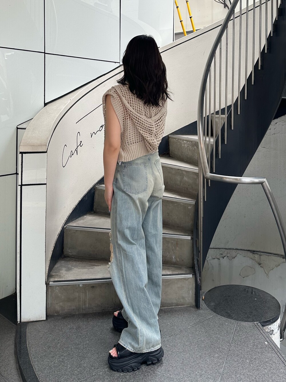 ホワイト系のニット/セーター、ブルー系のデニムパンツ、ブラック系のサンダルを着用したレディースの夏コーディネートの3枚目の写真