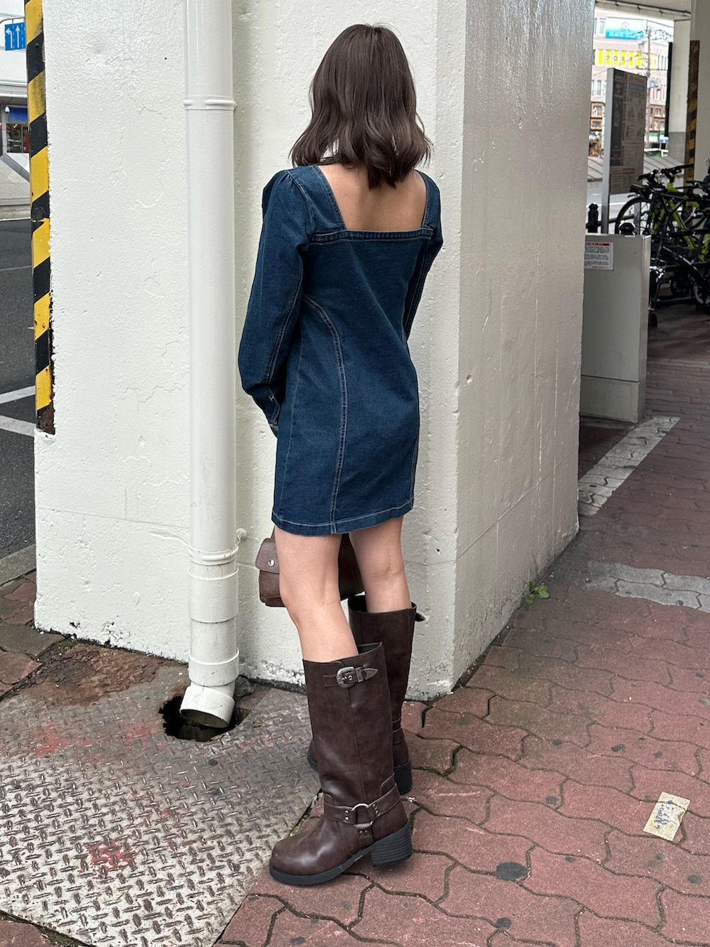 ブラウン系のブーツ、ブルー系のワンピース、ブラウン系のハンドバッグを着用したレディースの冬コーディネートの3枚目の写真