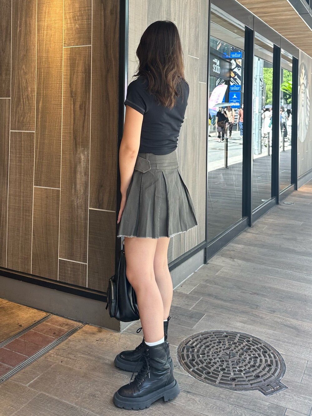 ブラック系のTシャツ/カットソー、グレー系のスカート、ブラック系のハンドバッグを着用したレディースの夏コーディネートの3枚目の写真