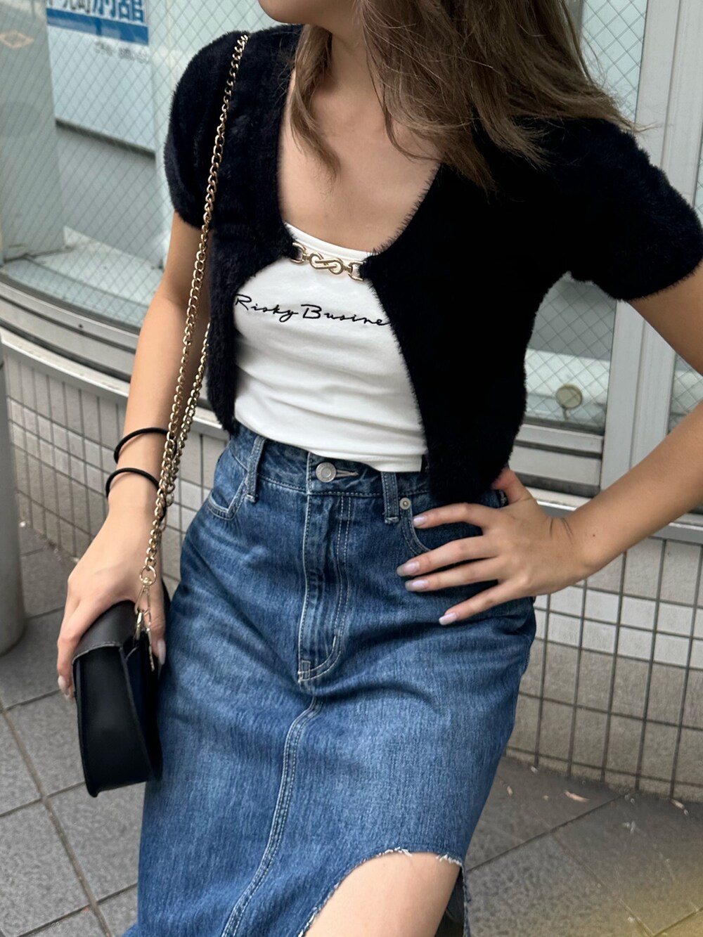 ブルー系のデニムスカート、ブラック系のサンダル、ブラック系のニット/セーターを着用したレディースの夏コーディネートの5枚目の写真