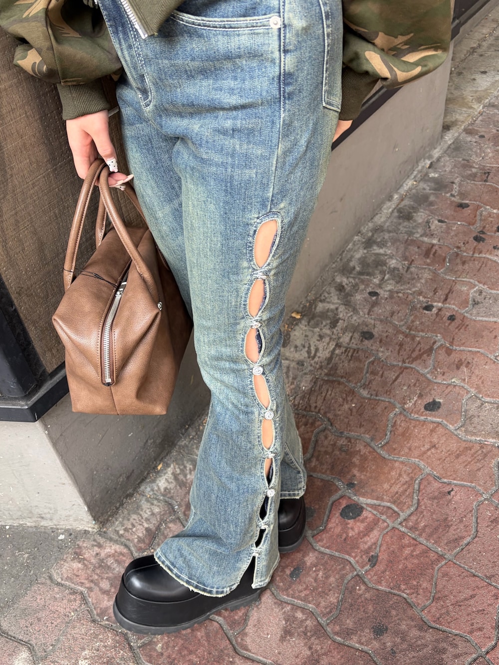 ブルー系のデニムパンツ、ブラウン系のボストンバッグ、ブラック系のブーツを着用したレディースの冬コーディネートの6枚目の写真