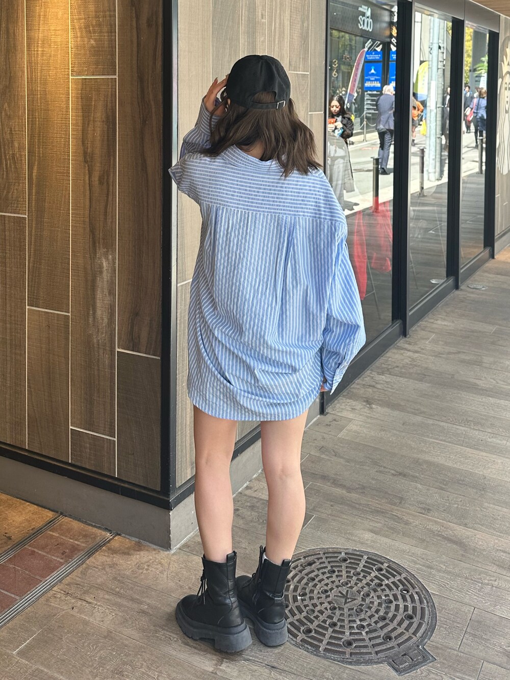 ブルー系のシャツ/ブラウス、ブラック系のブーツ、ベージュ系のデニムパンツを着用したレディースの春コーディネートの3枚目の写真