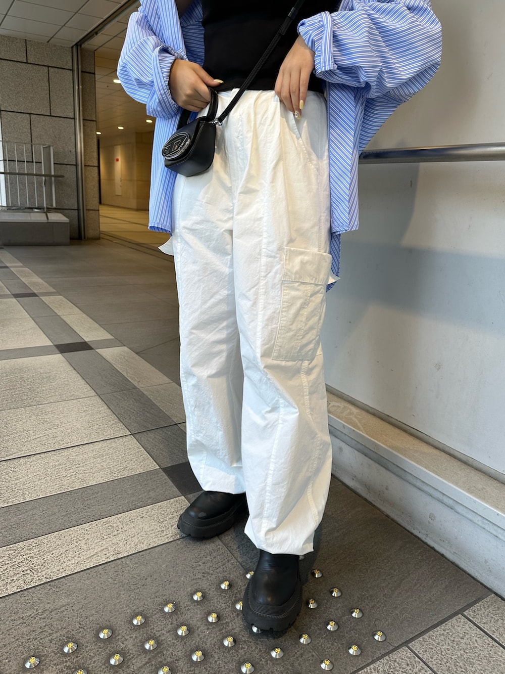 ブラック系のタンクトップ、ブルー系のシャツ/ブラウス、ホワイト系のカーゴパンツを着用したレディースの春コーディネートの7枚目の写真