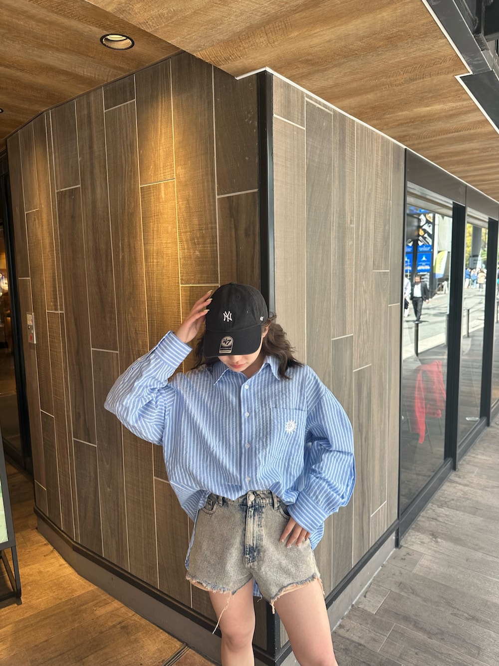 ブルー系のシャツ/ブラウス、ブラック系のブーツ、ベージュ系のデニムパンツを着用したレディースの春コーディネートの5枚目の写真