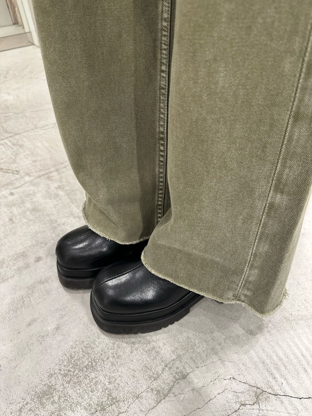 グリーン系のデニムパンツ、グレー系のニット/セーター、ブラック系のショルダーバッグを着用したレディースの冬コーディネートの9枚目の写真