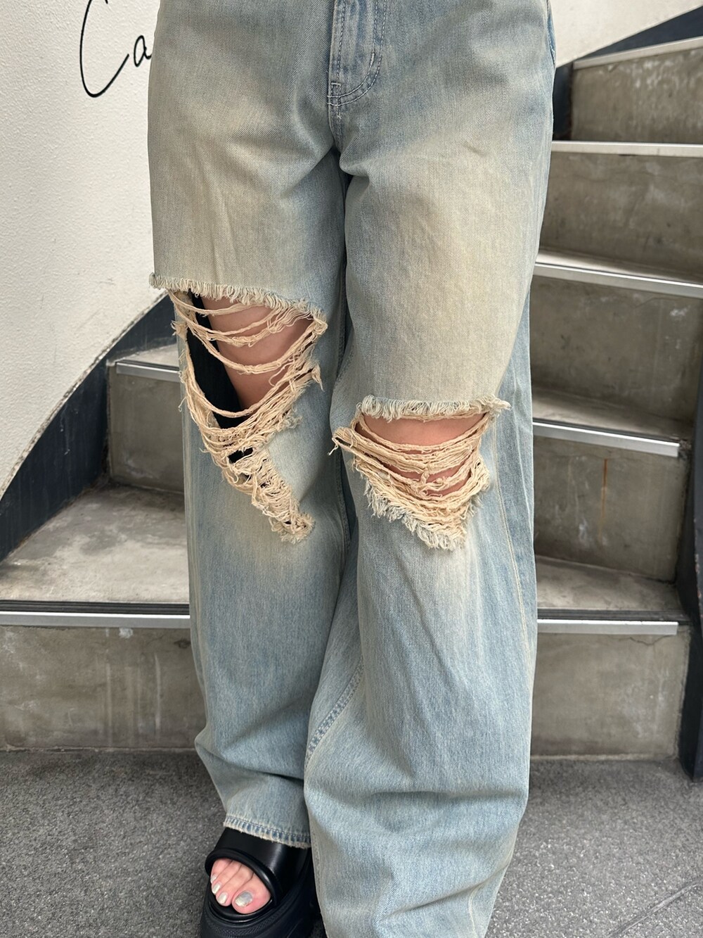 ホワイト系のニット/セーター、ブルー系のデニムパンツ、ブラック系のサンダルを着用したレディースの夏コーディネートの8枚目の写真