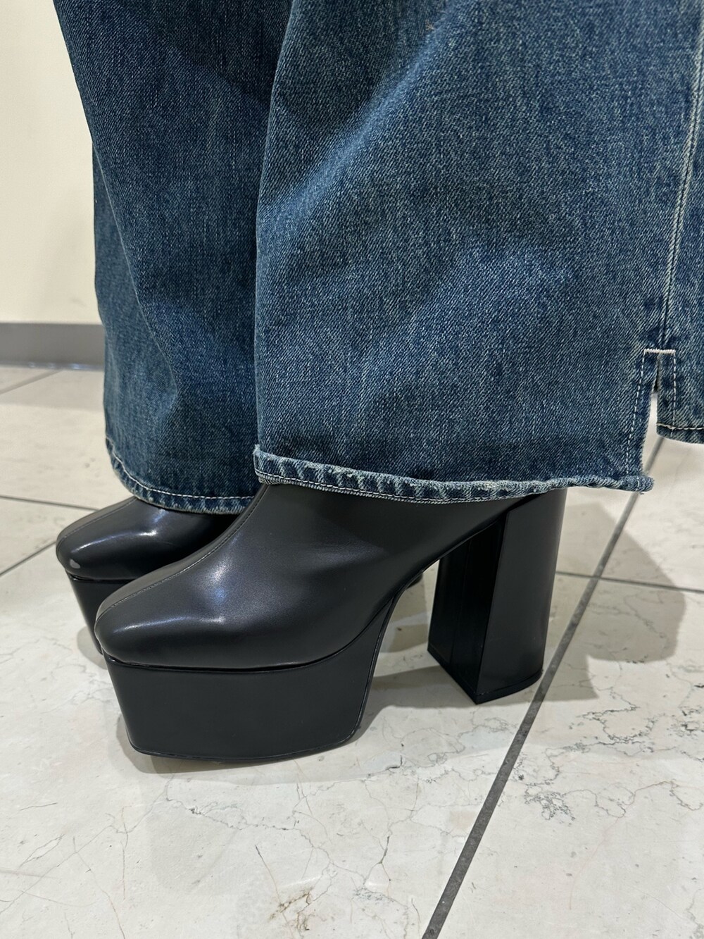 ブルー系のデニムパンツ、ブラック系のショルダーバッグ、ブラック系のブーツを着用したレディースの冬コーディネートの9枚目の写真