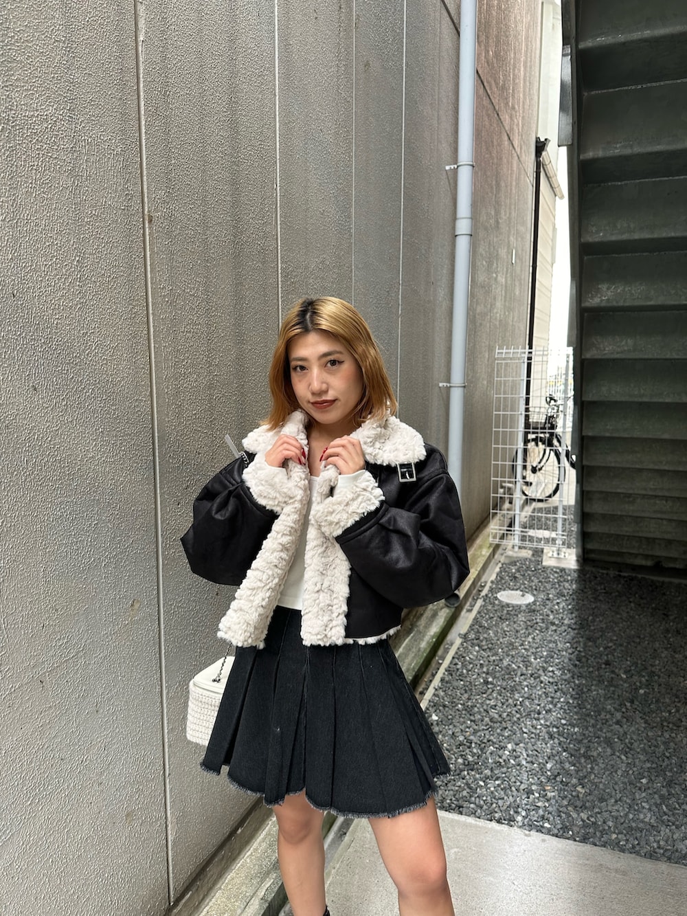 ブラック系のデニムスカート、その他のブーツ、ホワイト系のショルダーバッグを着用したレディースの秋コーディネートの4枚目の写真