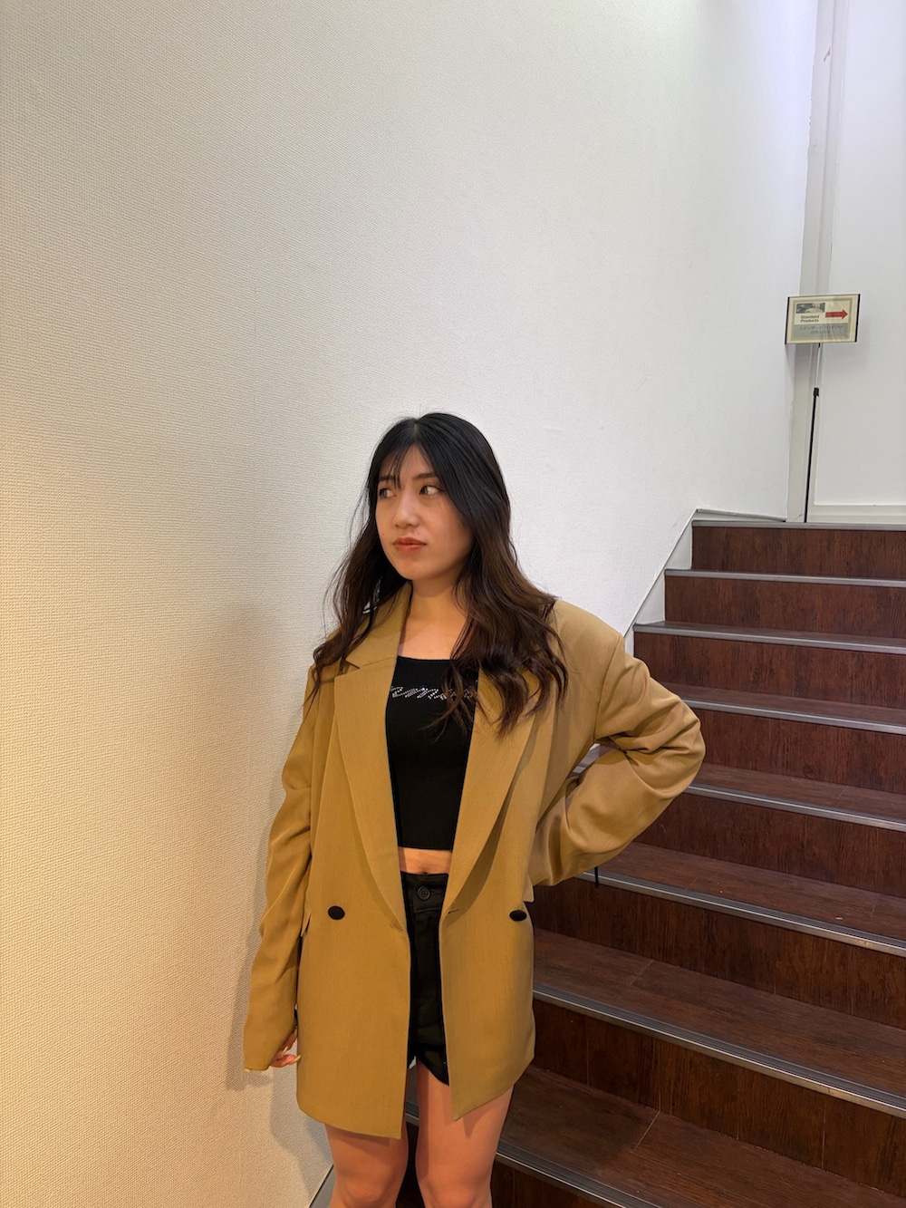 ブラウン系のテーラードジャケット、ブラック系のニット/セーター、ブラック系のその他パンツを着用したレディースの春コーディネートの5枚目の写真