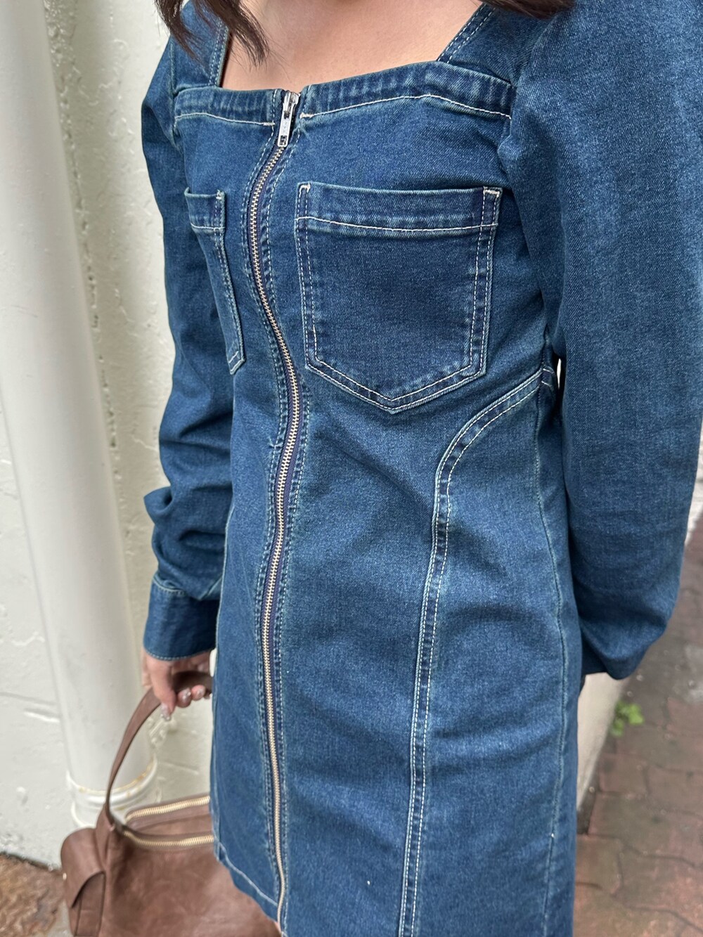 ブラウン系のブーツ、ブルー系のワンピース、ブラウン系のハンドバッグを着用したレディースの冬コーディネートの7枚目の写真