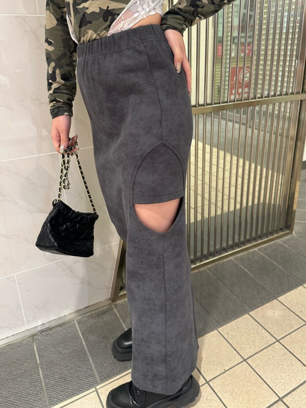 ブラック系のブーツ、ブラック系のスカート、ブラック系のショルダーバッグを着用したレディースの冬コーディネートの8枚目の写真