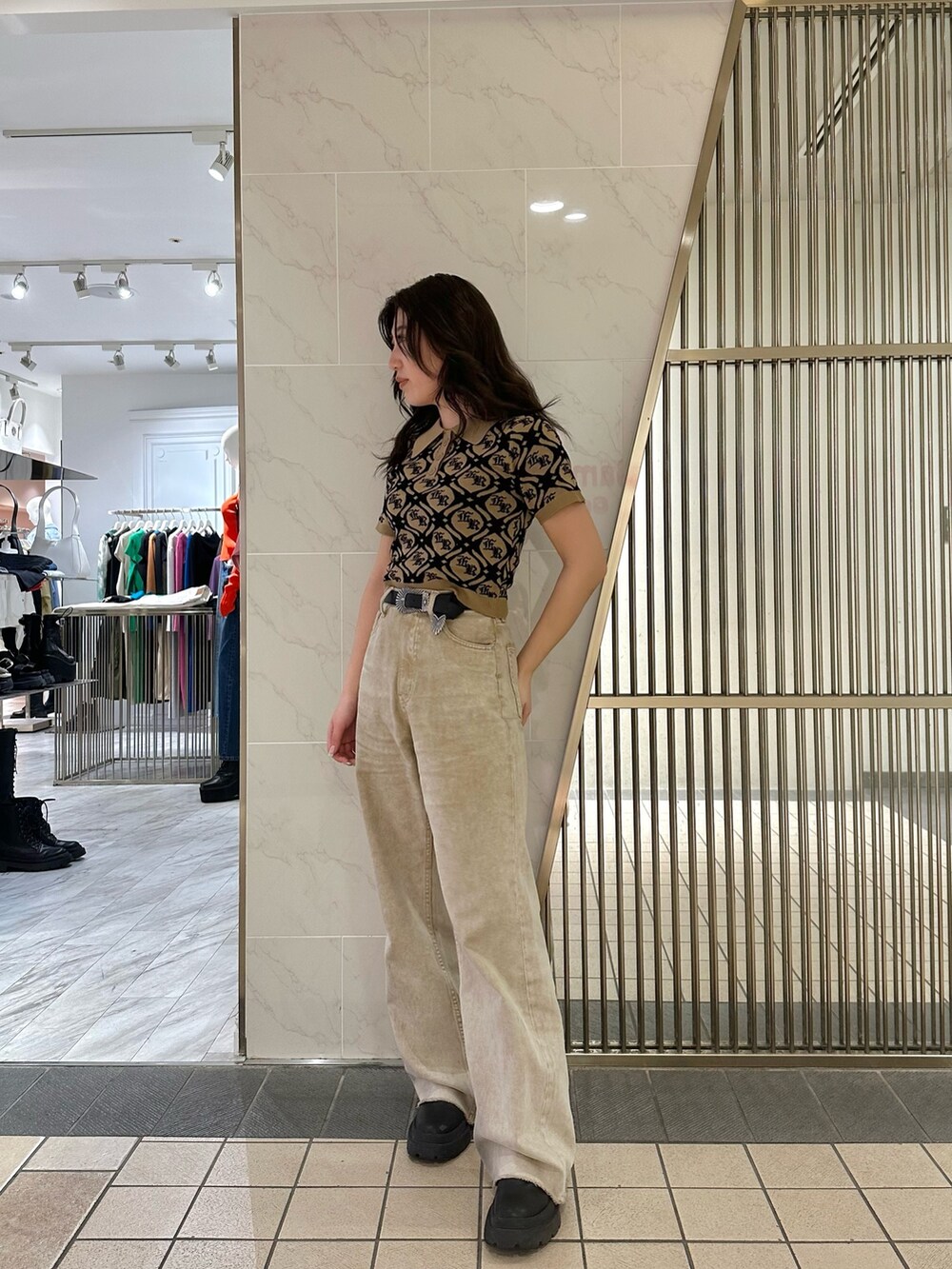ベージュ系のニット/セーター、ベージュ系のデニムパンツ、ブラック系のブーツを着用したレディースの春コーディネートの2枚目の写真