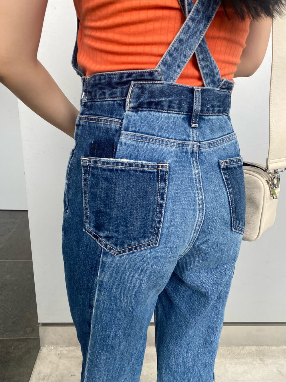 ホワイト系のショルダーバッグ、ブルー系のサロペット/オーバーオール、オレンジ系のタンクトップを着用したレディースの夏コーディネートの5枚目の写真