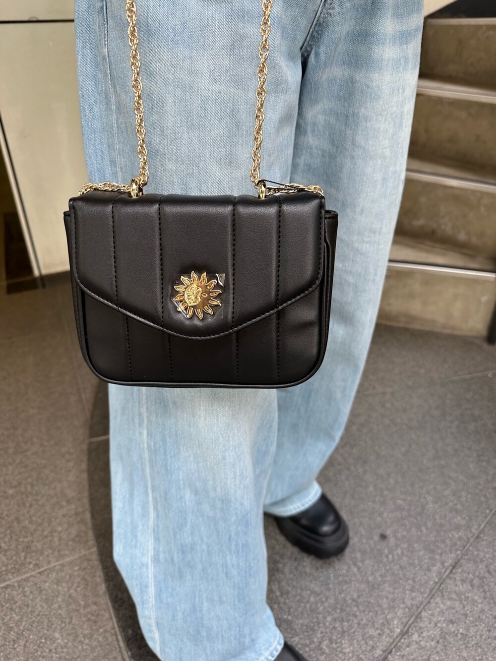 ブルー系のデニムパンツ、グリーン系のチューブトップ、ブラック系のショルダーバッグを着用したレディースの夏コーディネートの8枚目の写真
