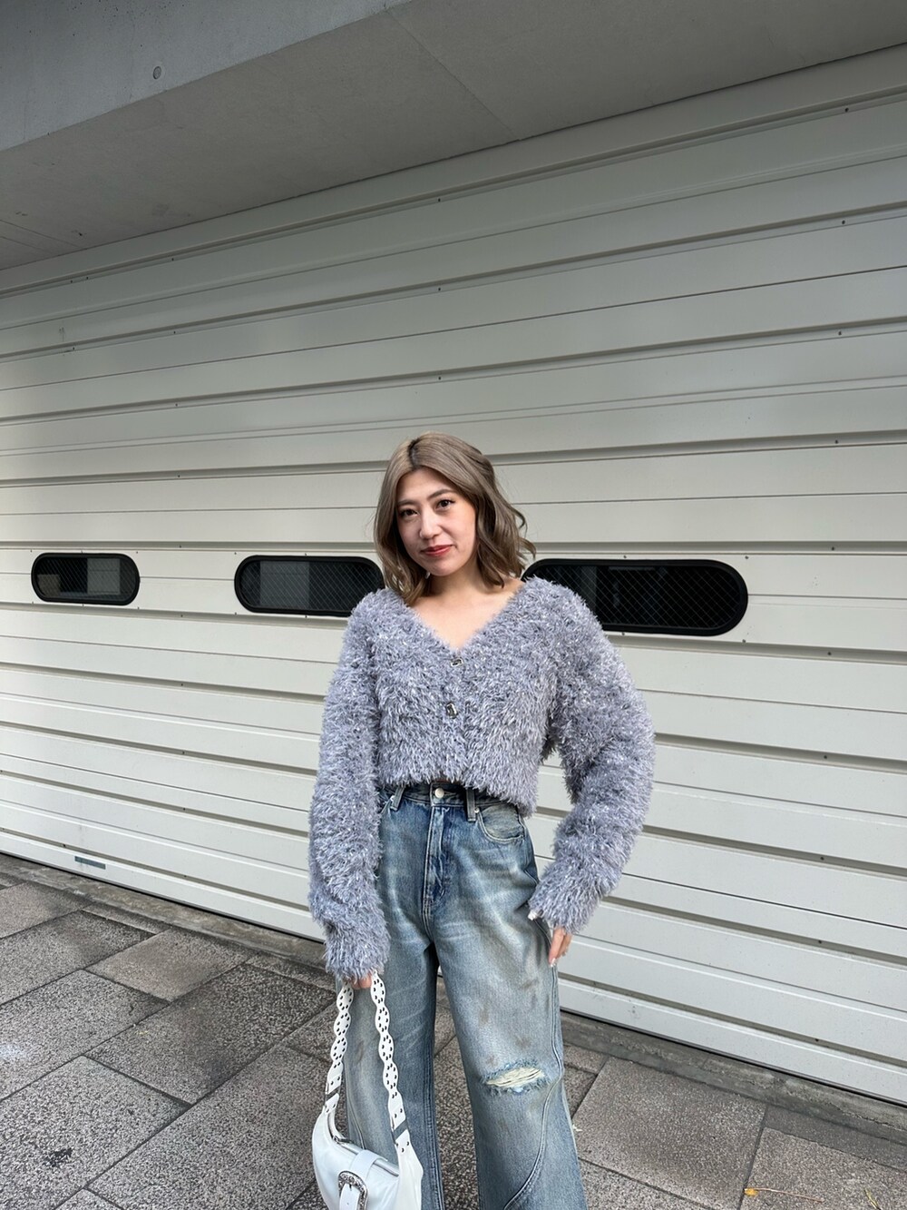 グレー系のカーディガン/ボレロ、ブルー系のデニムパンツを着用したレディースの冬コーディネートの5枚目の写真