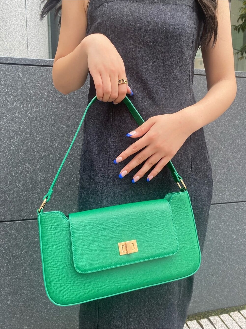 ブラック系のワンピース、グリーン系のショルダーバッグ、ブラック系のブーツを着用したレディースの夏コーディネートの7枚目の写真