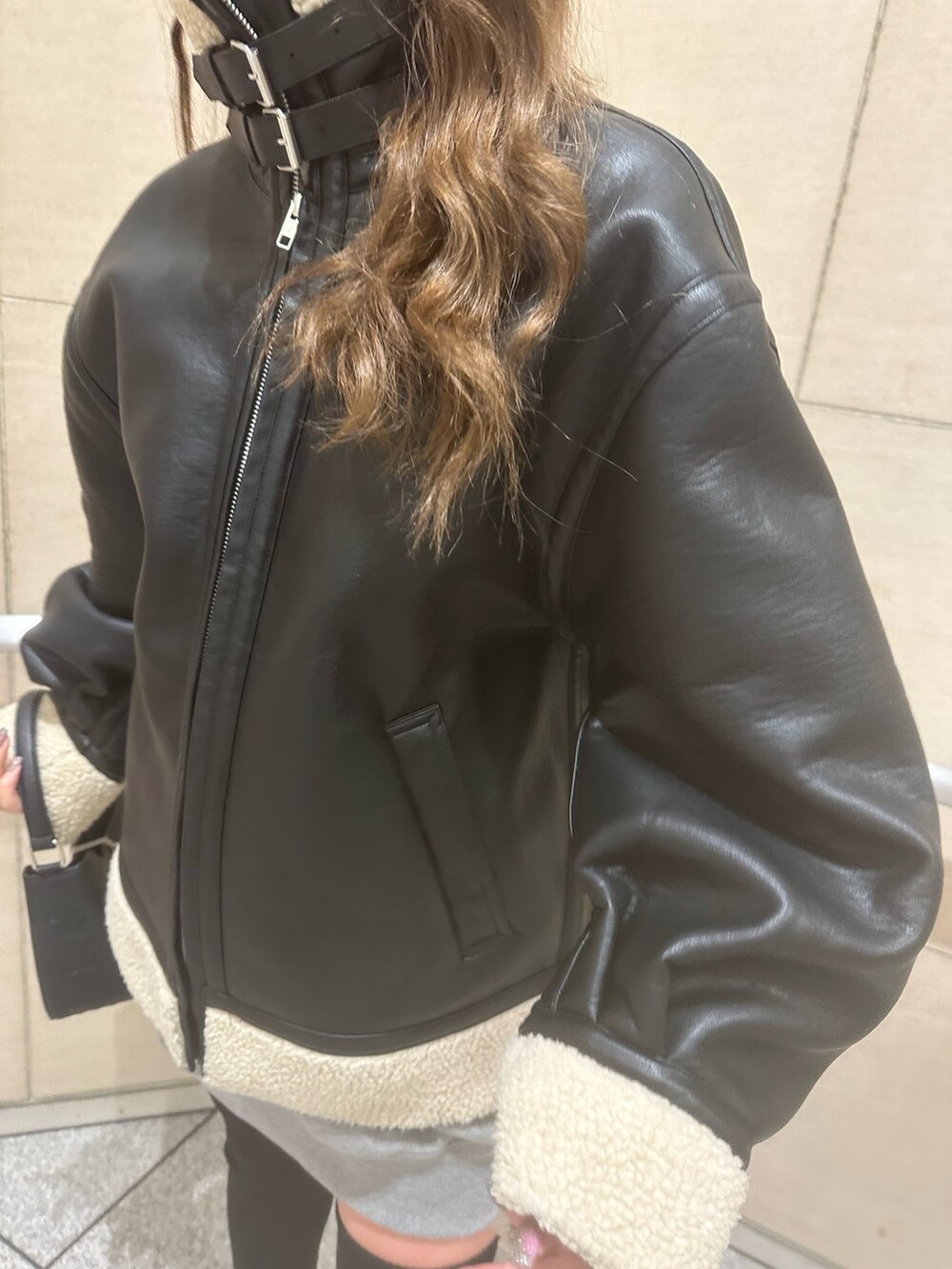 グレー系のスウェット、ブラック系のブルゾン、ブラック系のハンドバッグを着用したレディースの冬コーディネートの7枚目の写真