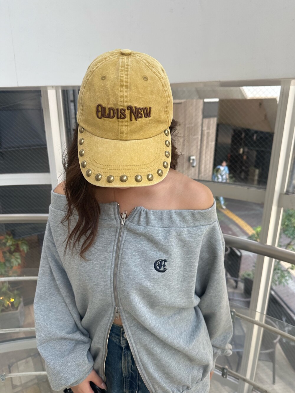 ブルー系のデニムパンツ、グレー系のパーカー、ブラック系のハンドバッグを着用したレディースの秋コーディネートの7枚目の写真