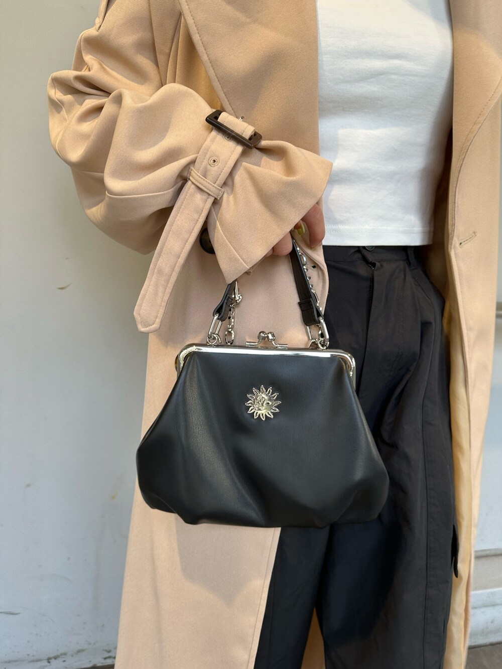 ベージュ系のトレンチコート、ブラック系のカーゴパンツ、ホワイト系のTシャツ/カットソーを着用したレディースの春コーディネートの6枚目の写真